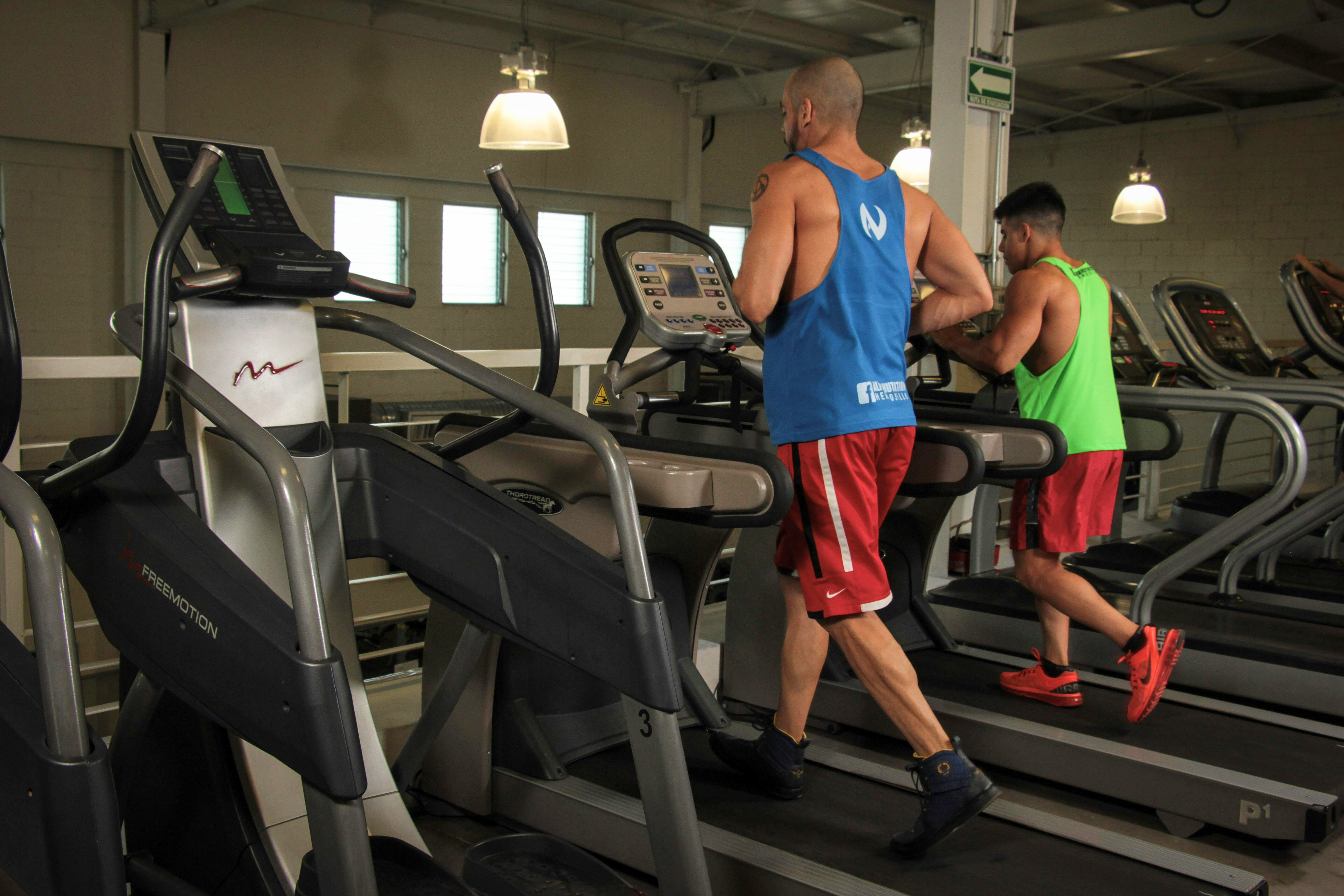 Men working out on gym treadmills, fitness equipment, exercise routine